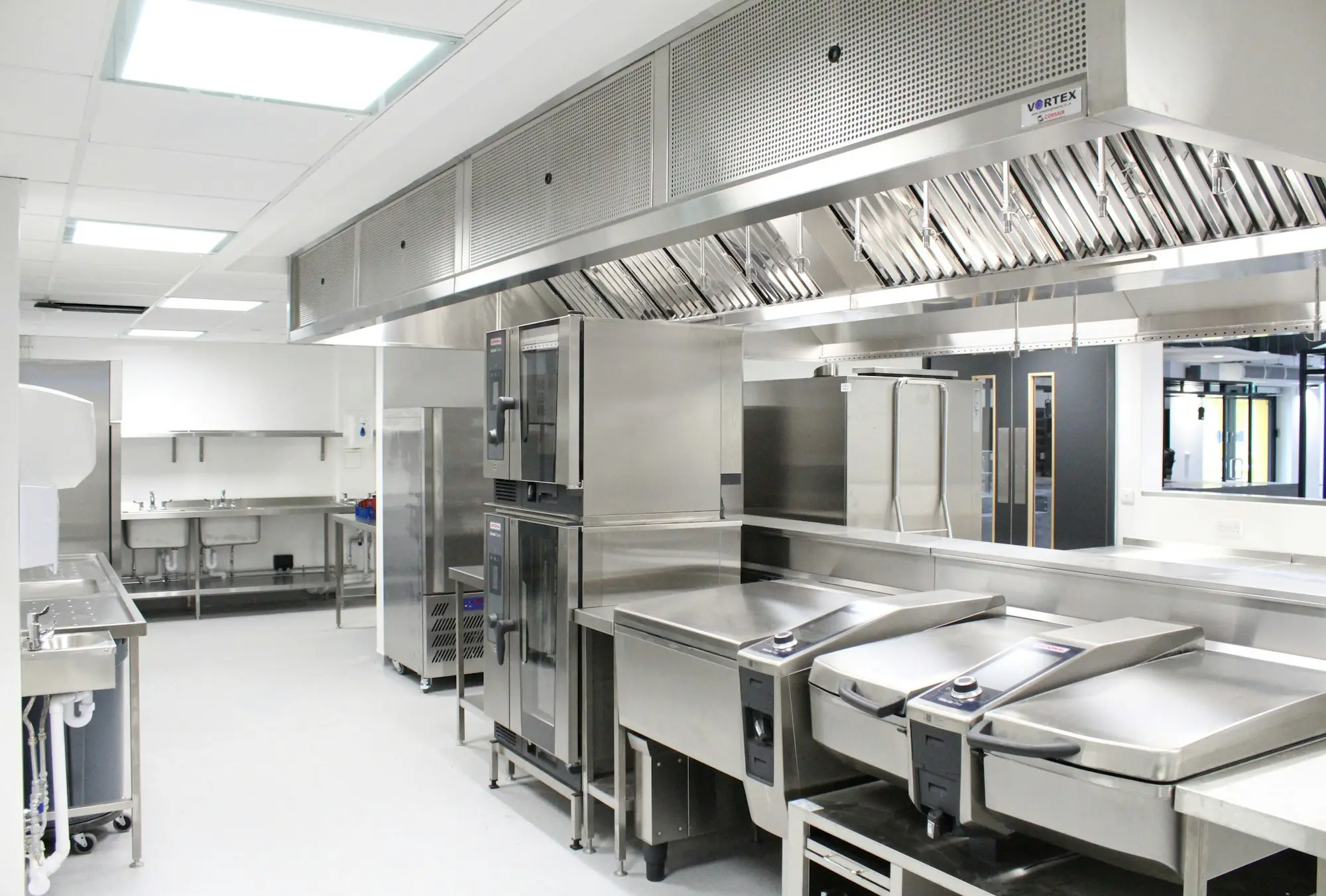 Chef checking a new combi oven in a stainless-steel commercial kitchen
