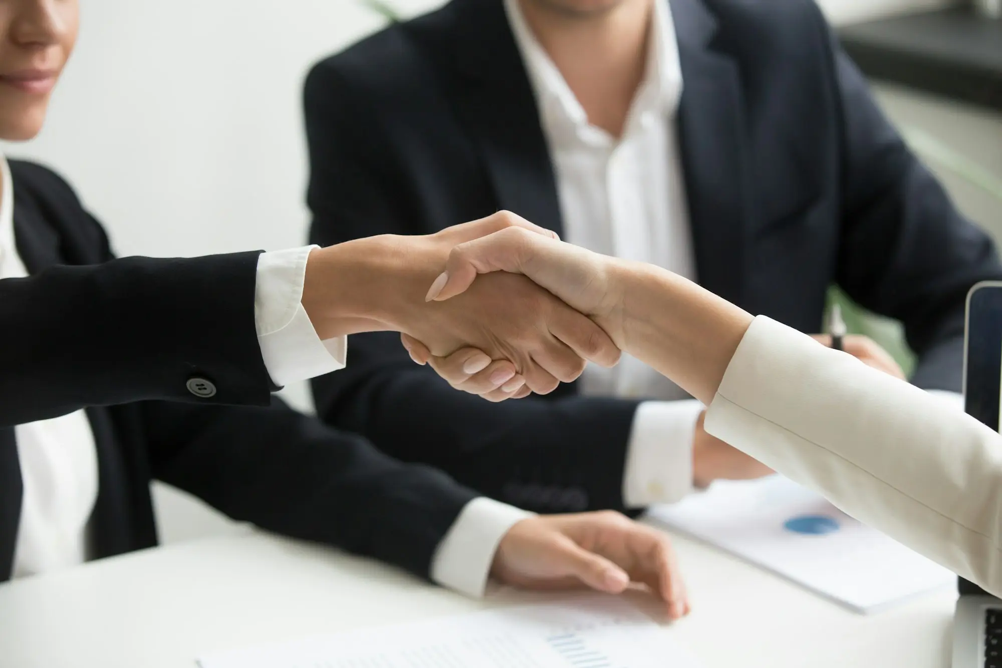 Seller handing keys to the new owner across the counter of an established business