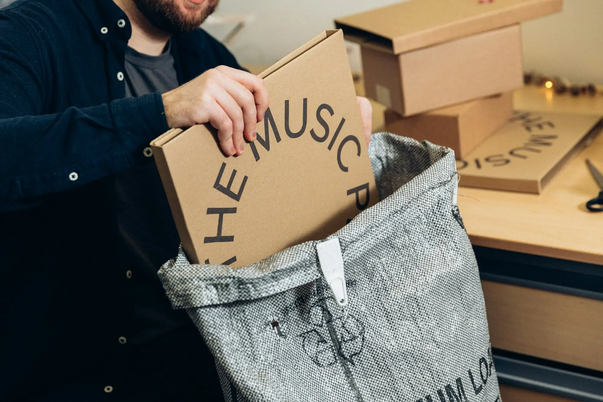 Online store owner packing customer orders at a bench with boxes and labels