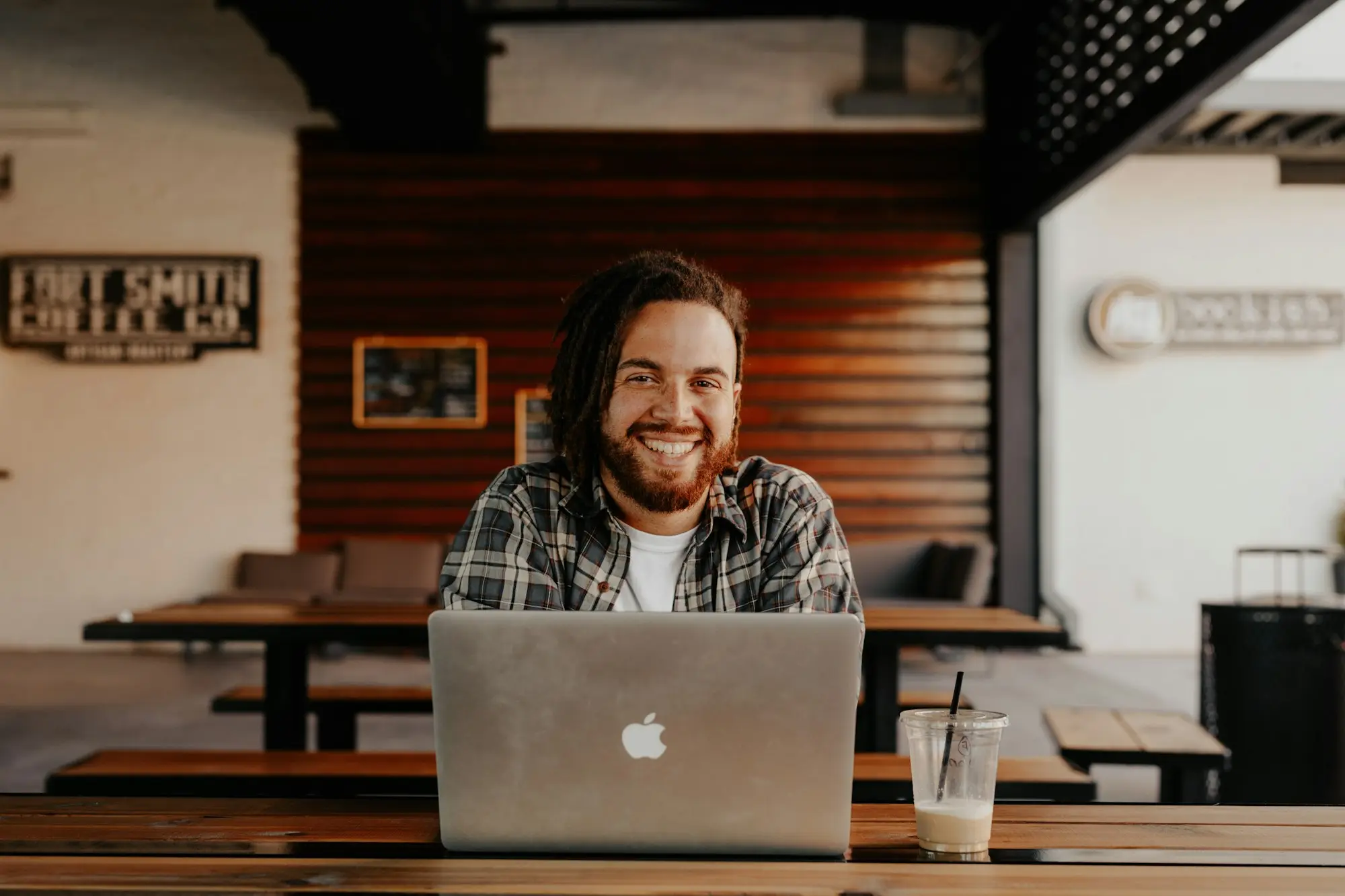 Small-business owner reviewing a cash flow spreadsheet on a laptop with invoices